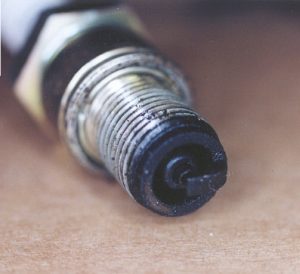 Rich jetting causes spark plug to foul with oil residue