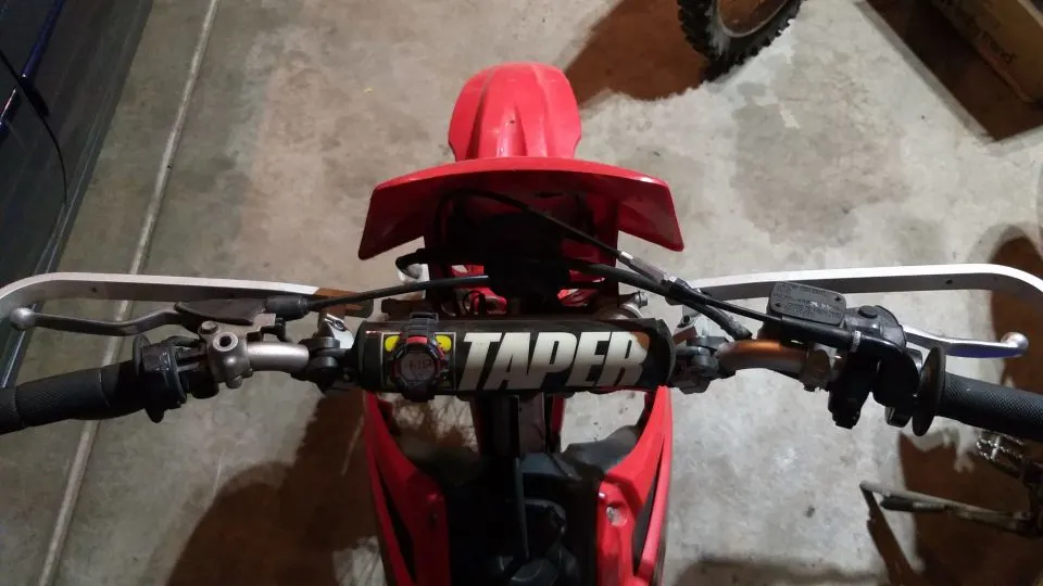 Dirt bike handlebar controls; clutch on left, front brake on right.