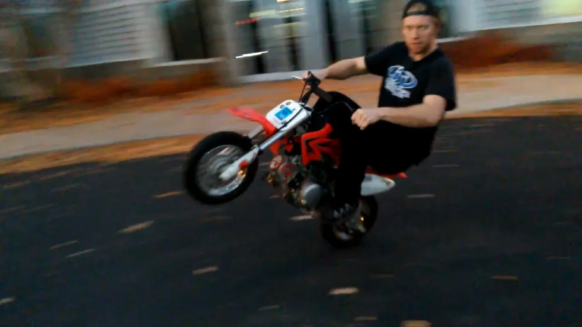 Riding a wheelie on a Honda CRF50 pit bike without any riding gear